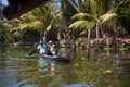 An Indian male fisherman on a traditional wooden boat sails through a channel overgrown with algae Royalty Free Stock Photo