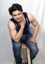 Indian male model in black vest sitting in chair