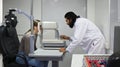 Indian male ophthalmologist checking eyesight female patient with auto refractor in ophthalmologist clinic