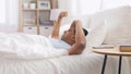 Indian man awaking and stretching in bed at home