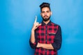 Indian man with beard raising index finger up while having brilliant idea isolated on blue background Royalty Free Stock Photo