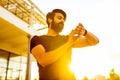 indian man in black t-shirt check time outdoors in sunset gold lights