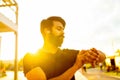 indian man in black t-shirt check time outdoors in sunset gold lights
