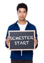 Indian man with chalkboard showing phrases of semester start