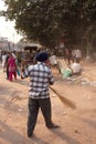 Indian man cleaning street after Guru Nanak Gurpurab celebration