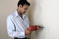 Indian man drilling hole in a wall