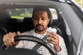 indian man or driver with coffee driving car