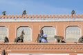 Indian man feeds the hungry monkeys next Hawa Mahal, Jaipur, Rajasthan, India