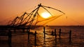 Indian man fishing under the great Chinese nets at Cochin, Kerela, India.