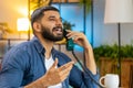 Indian man freelancer working talking with client on retro old-fashioned wired telephone at home Royalty Free Stock Photo