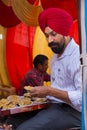 Indian man giving away rice at Guru Nanak Gurpurab celebration,