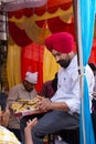 Indian man giving away rice at Guru Nanak Gurpurab celebration,