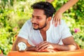 Indian man having oil Ayurveda spa treatment.handsome bearded dark haired male model relaxing on beach.spa and