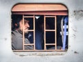 Indian man in headphones is sitting in train, and looking through the train window in Sambhar. Rajasthan. India