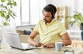 Indian man with headset and laptop working at home Royalty Free Stock Photo