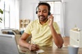 Indian man with headset and laptop working at home Royalty Free Stock Photo