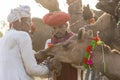 Indian man and herd camels during Pushkar Camel Mela, Rajasthan, India Royalty Free Stock Photo