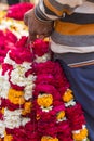 Indian man holding bunches of floral garlands at a market in Varanasi, India Royalty Free Stock Photo