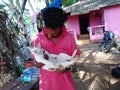 Indian man with a cat, Morjim village, Goa, India