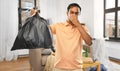 Indian man holding stinky trash bag