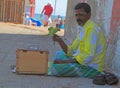 Indian man holds a parrot in street