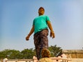 an indian man kept shoe on football during match on sky background in india January 2020 Royalty Free Stock Photo