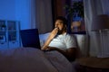 indian man with laptop in bed at home at night Royalty Free Stock Photo