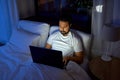 indian man with laptop in bed at home at night Royalty Free Stock Photo