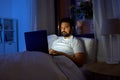 indian man with laptop in bed at home at night Royalty Free Stock Photo