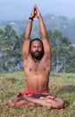 Indian man meditating in lotus yoga pose on green grass in Kerala, India Royalty Free Stock Photo