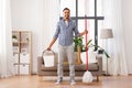 Indian man with mop and bucket cleaning at home