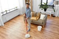 Indian man with mop and bucket cleaning at home