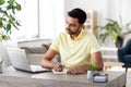 Indian man with notebook and laptop at home office Royalty Free Stock Photo