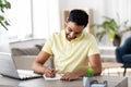 Indian man with notebook and laptop at home office Royalty Free Stock Photo