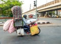 Indian man on an overladen motorcycle riding through Delhi in India