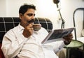 Indian man reading newspaper and having a hot beverage Royalty Free Stock Photo