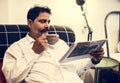 Indian man reading newspaper at home