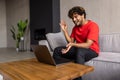 Indian man relaxing on couch while video calling using laptop at home. Asian man sitting on sofa and making a video call. Smiling Royalty Free Stock Photo