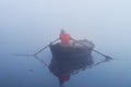 Indian man sailing on the boat on sacred river Ganges at cold foggy winter morning Royalty Free Stock Photo