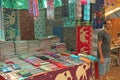 Indian man salesman in the Anjuna market, Goa, India. Indian markets, trade. A store of shawls and stoles