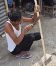 Indian Man sharpening a bamboo stick