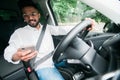 Indian handsome man sitting in a car and looking at a mobile phone Royalty Free Stock Photo