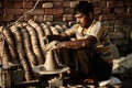 Indian man is sitting using his hands to sculpt the clay on a rotating tray to make a clay bowl Royalty Free Stock Photo