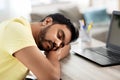 Indian man sleeping on table with laptop at home Royalty Free Stock Photo