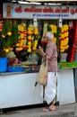 Indian man stands at Little India flower garland shop Singapore