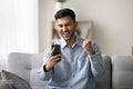 Indian man staring at mobile phone screen celebrate success Royalty Free Stock Photo