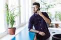 Indian man talking on phone in front modern office building Royalty Free Stock Photo