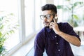 Indian man talking on phone in front modern office building Royalty Free Stock Photo