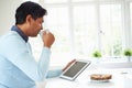 Indian Man Using Digital Tablet Whilst Eating Breakfast Royalty Free Stock Photo