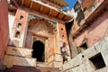 Indian man walk past old colorful temple gate